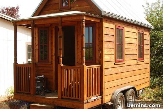 Tiny Houses: Sustainable Living for Everyone 3 A charming wooden tiny house on wheels, complete with a small porch, exemplifying mobile living.