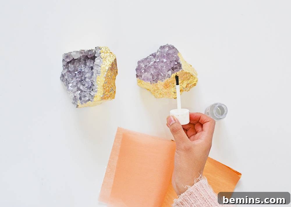 Gold leaf being applied to amethyst crystal