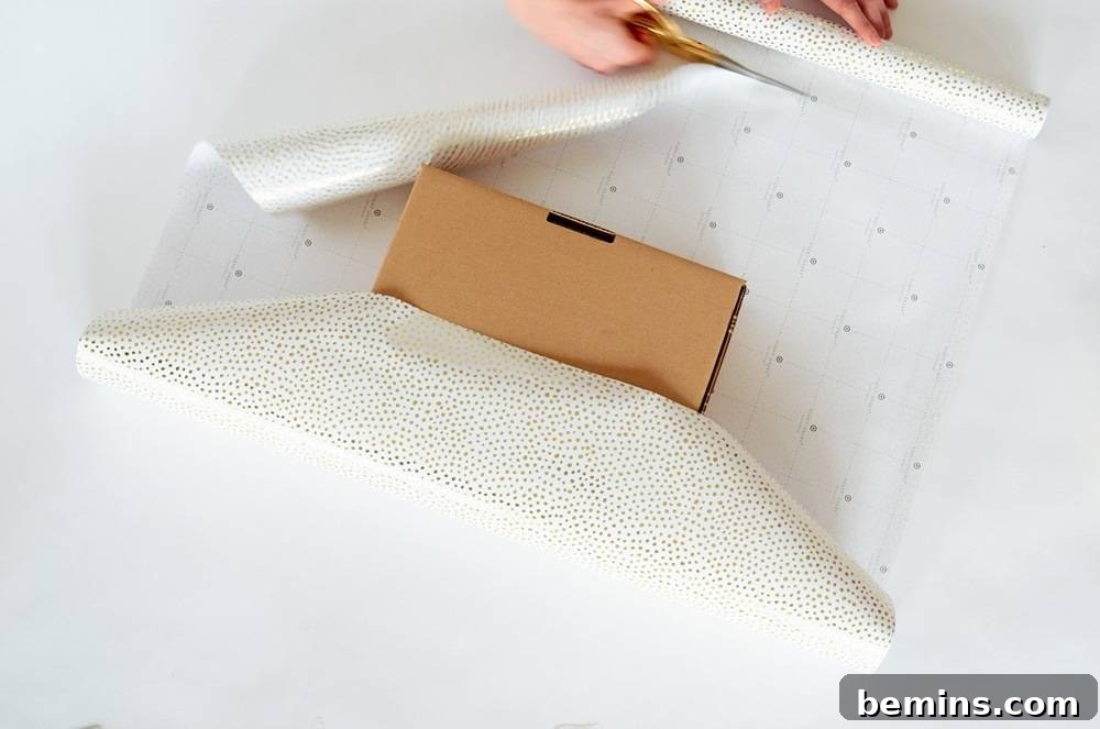 Placing a Brown Box on Prepared White Wrapping Paper Ready for Wrapping