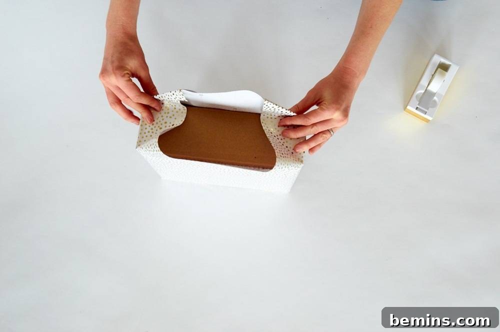 Two Hands Folding White Wrapping on a Brown Object to Create a Neat End