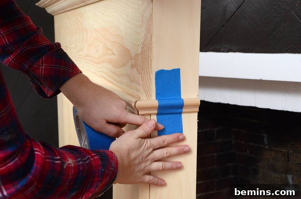 Crafting Your Own Fireplace Mantel 12 Applying small decorative molding to the sides of the DIY mantel with painter's tape