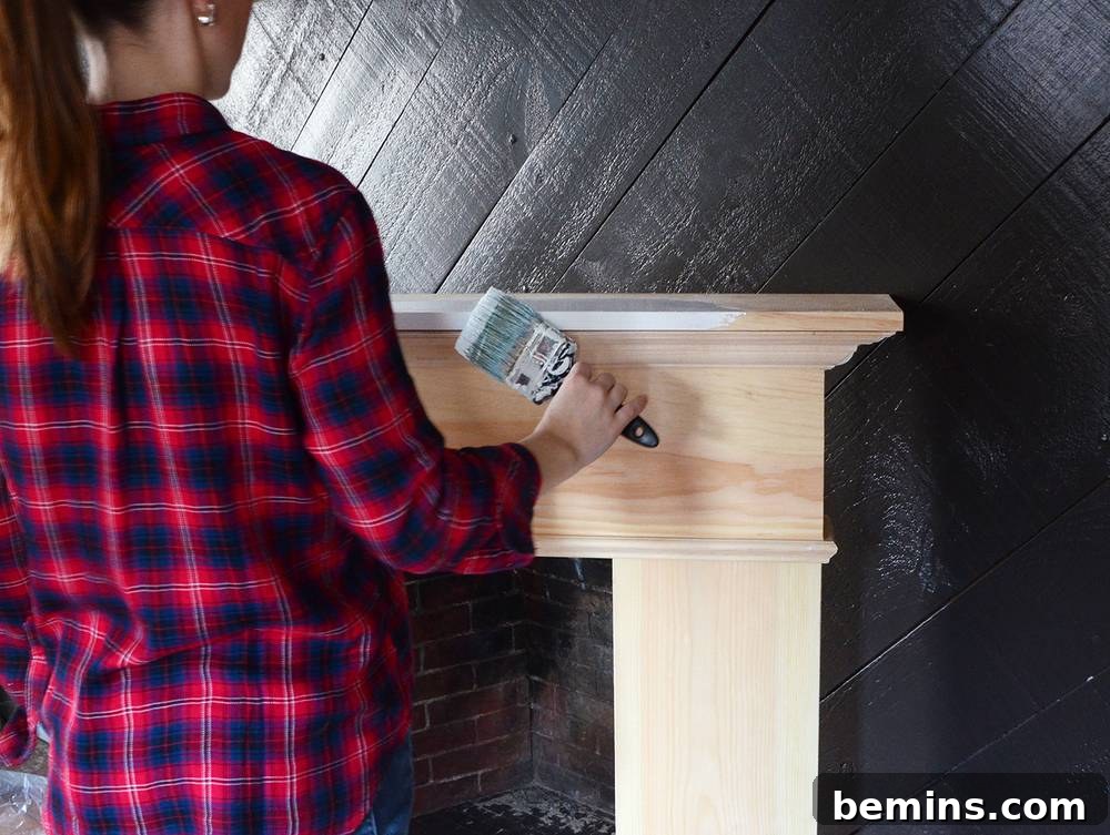 Crafting Your Own Fireplace Mantel 16 Painting the DIY wooden mantel with white paint and primer