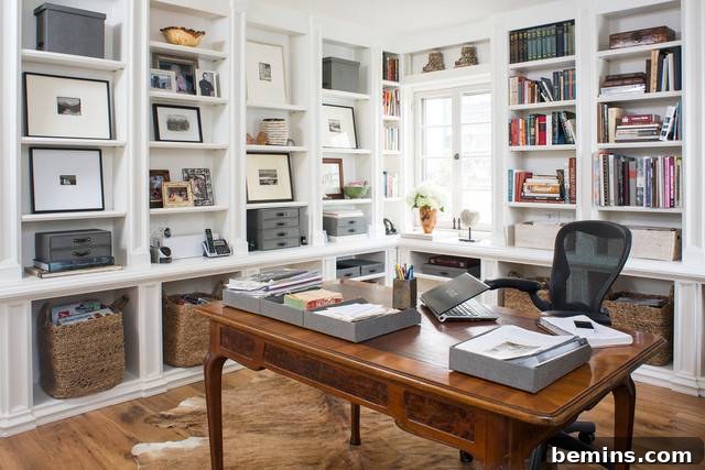 30 Impeccably Organized Studios for Creative Genius 31 Organized office space with framed artwork alternating with storage boxes.