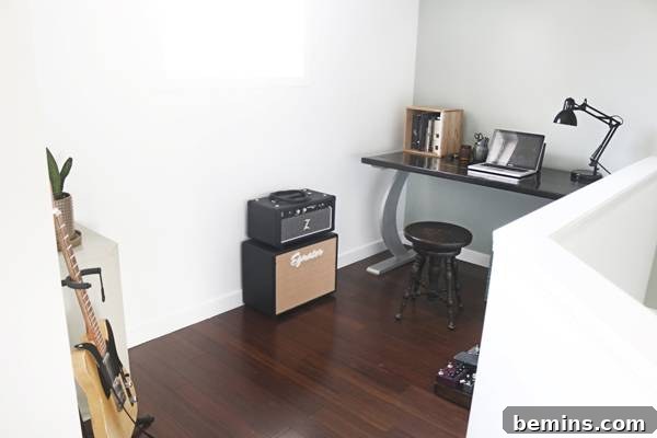 A minimalist home office space with a handmade desk by Trenton, a thrifted stool, and simple decor elements.