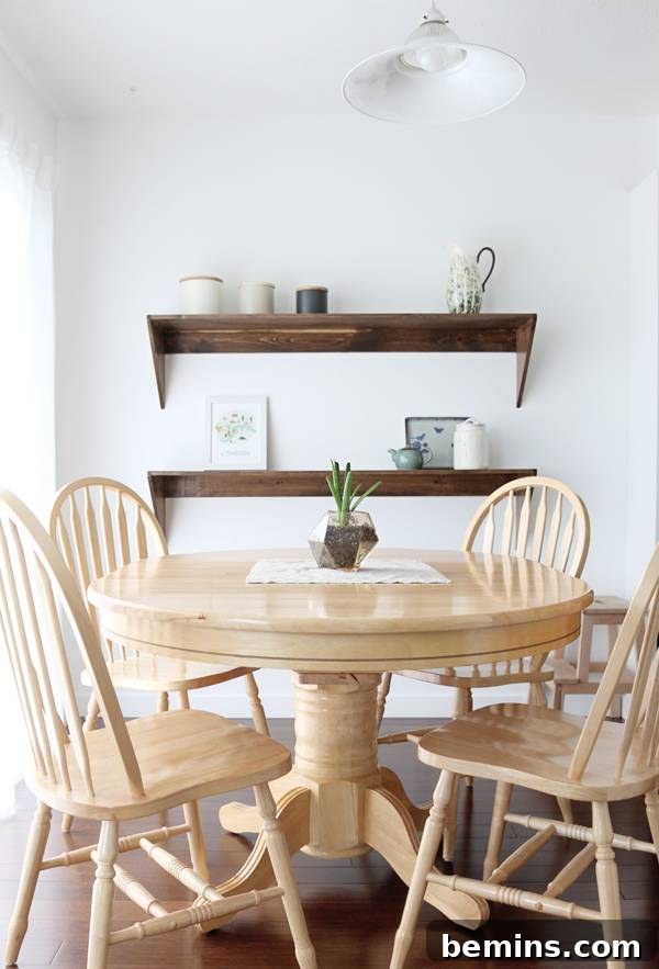 A minimalist dining table with thrifted chairs and a handmade floating shelf adorned with ceramic canisters from Crate & Barrel.
