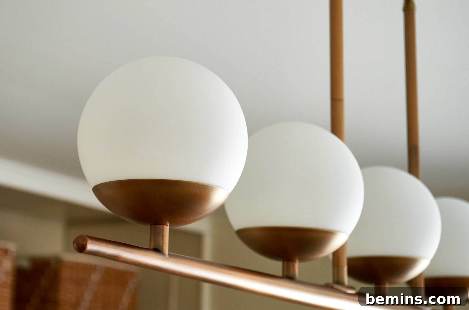 Modern chandelier with white globes and brass fixtures.