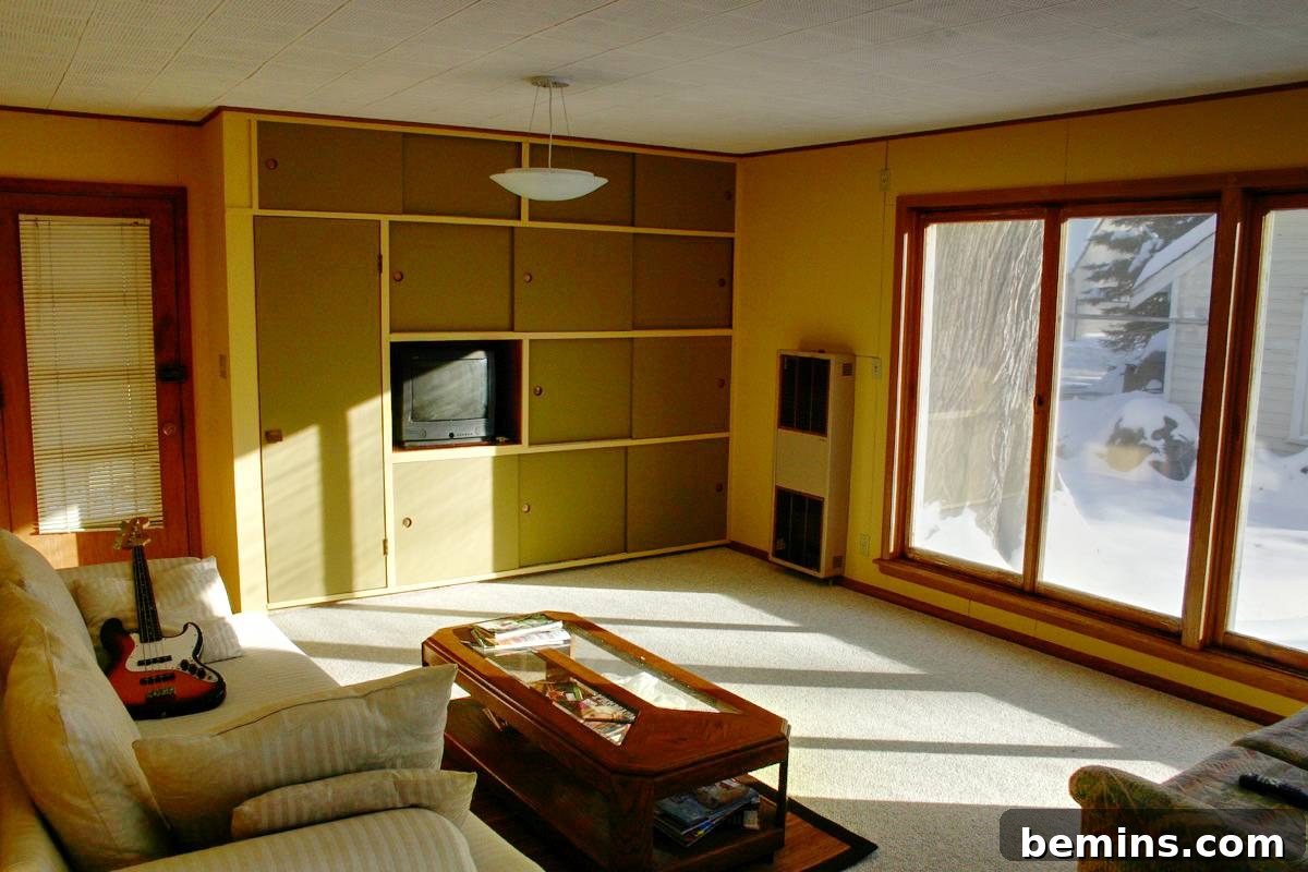 Original living room with yellow walls and basic furniture.