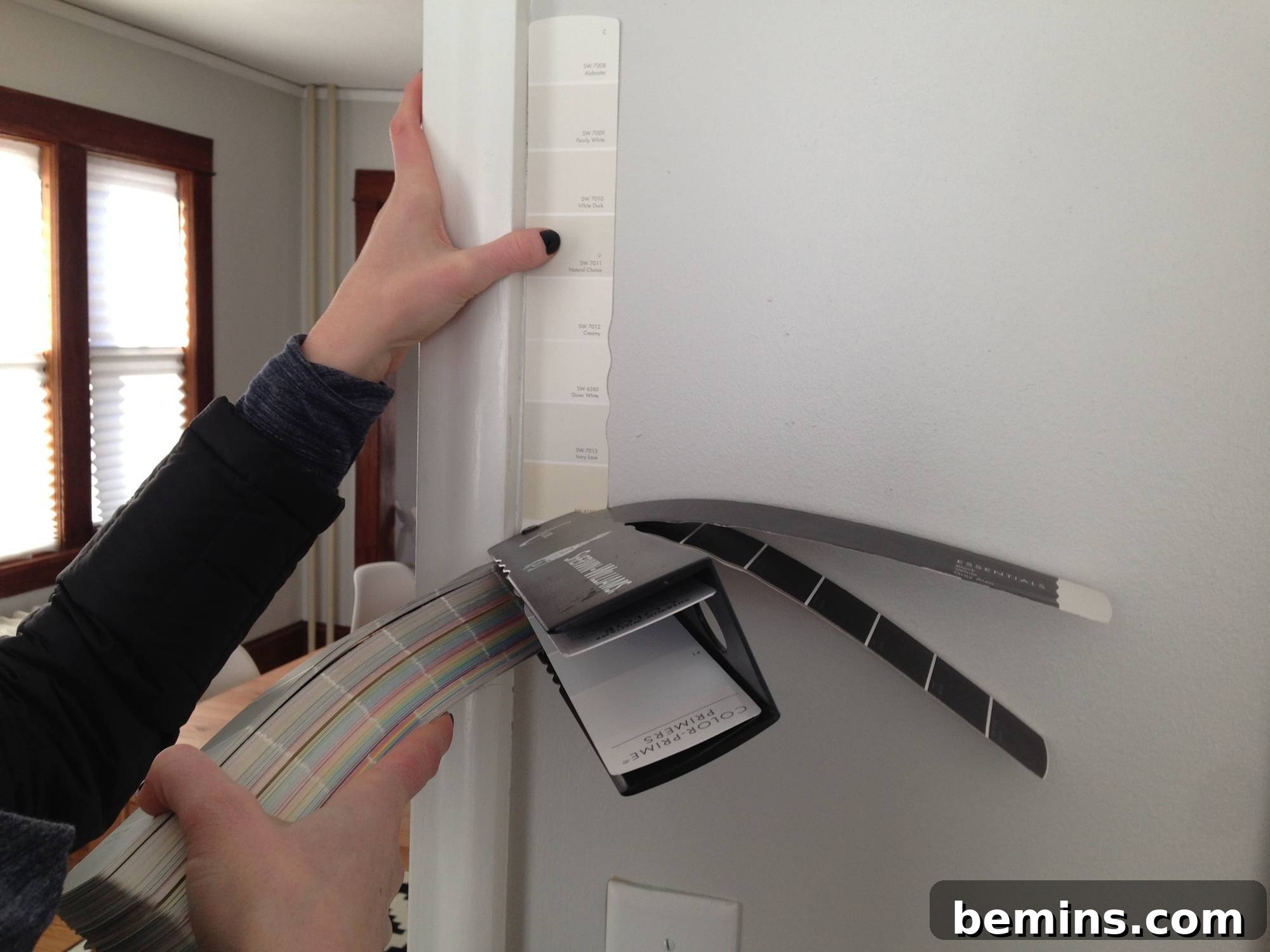 Paint color samples being compared against a wall.