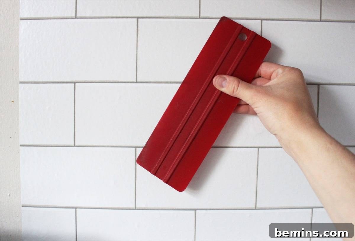 Use a squeegee to install temporary "tile" in your kitchen