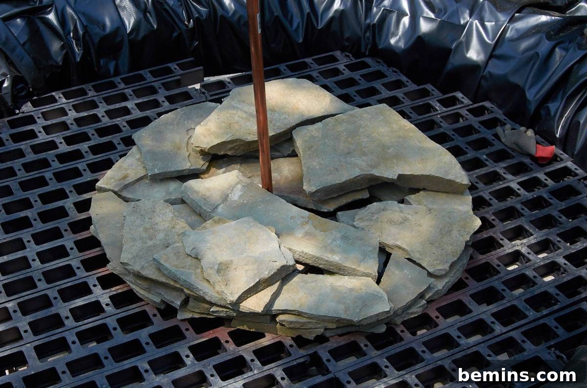 A white stone positioned in the middle of firewood, ready for use in the fountain construction.