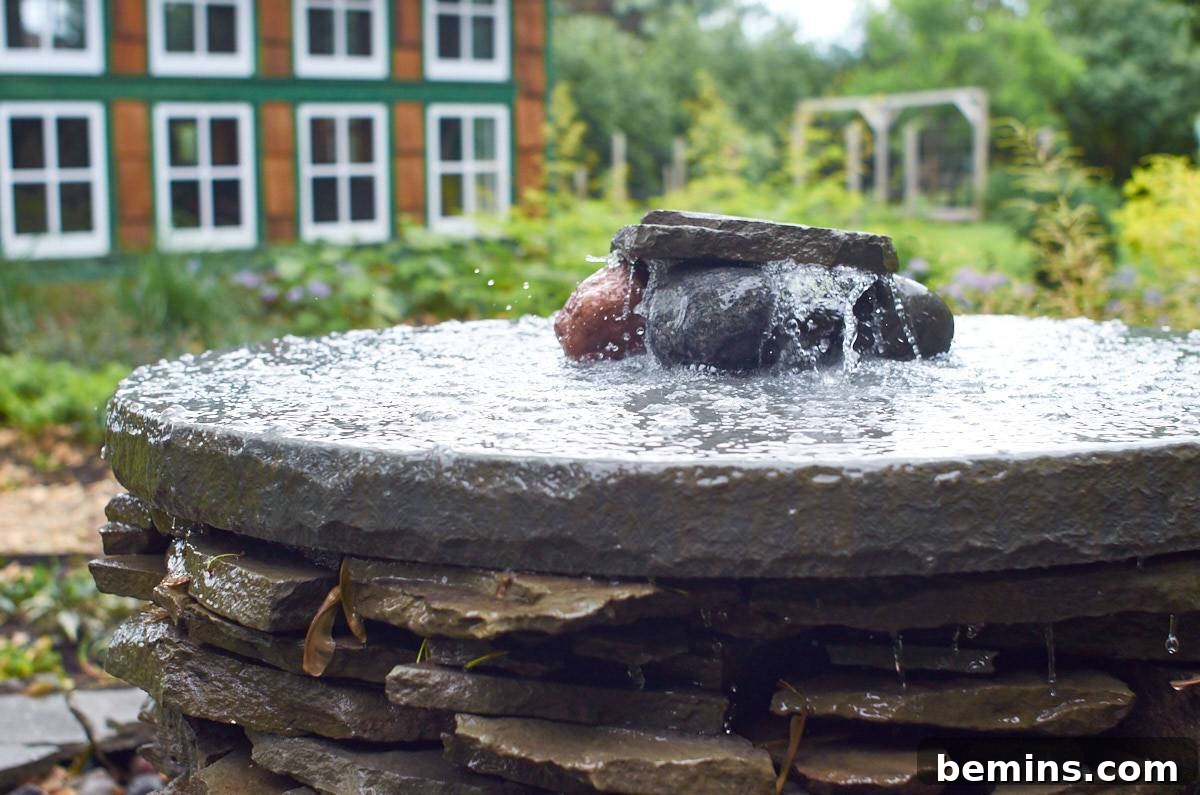 Creating a Backyard Oasis: A DIY Pond and Fountain Project 18 A small, round-shaped water fountain meticulously prepared with rocks, adding a touch of elegance to the landscape.