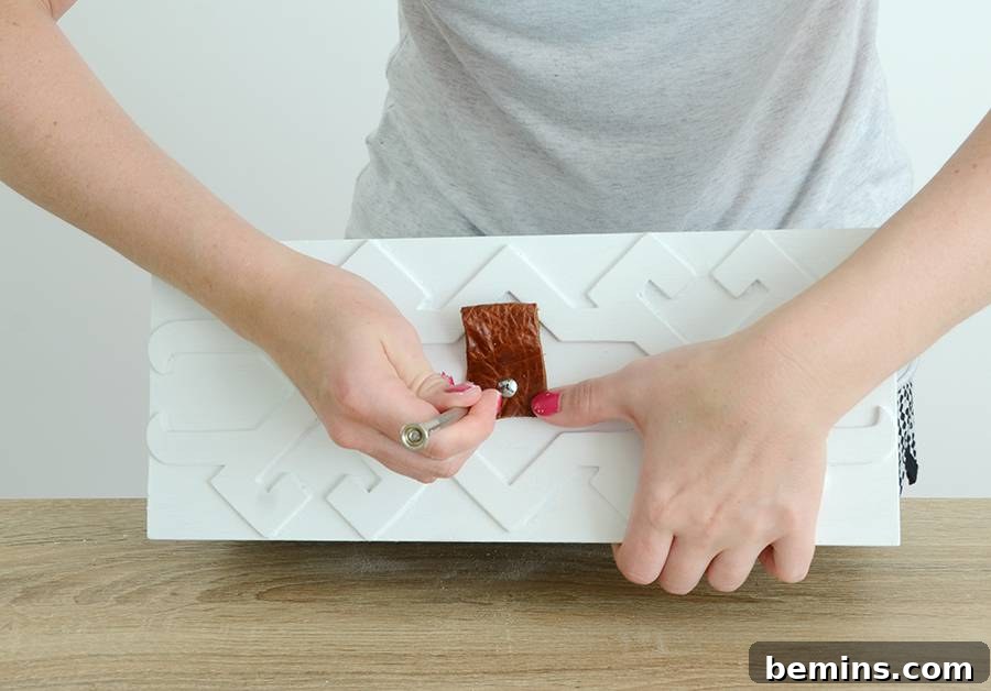 Making holes in the leather pulls with a hammer and nail
