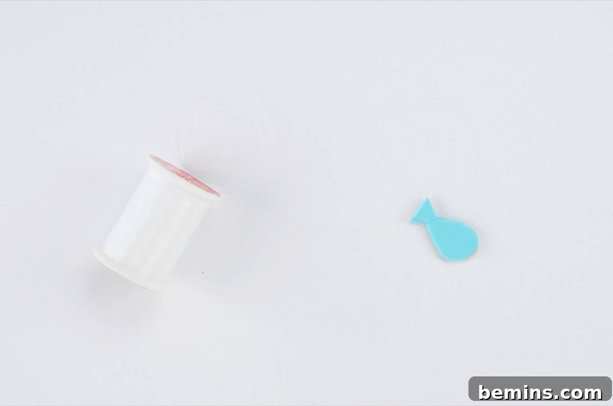Tying invisible thread to a foam fish for the craft