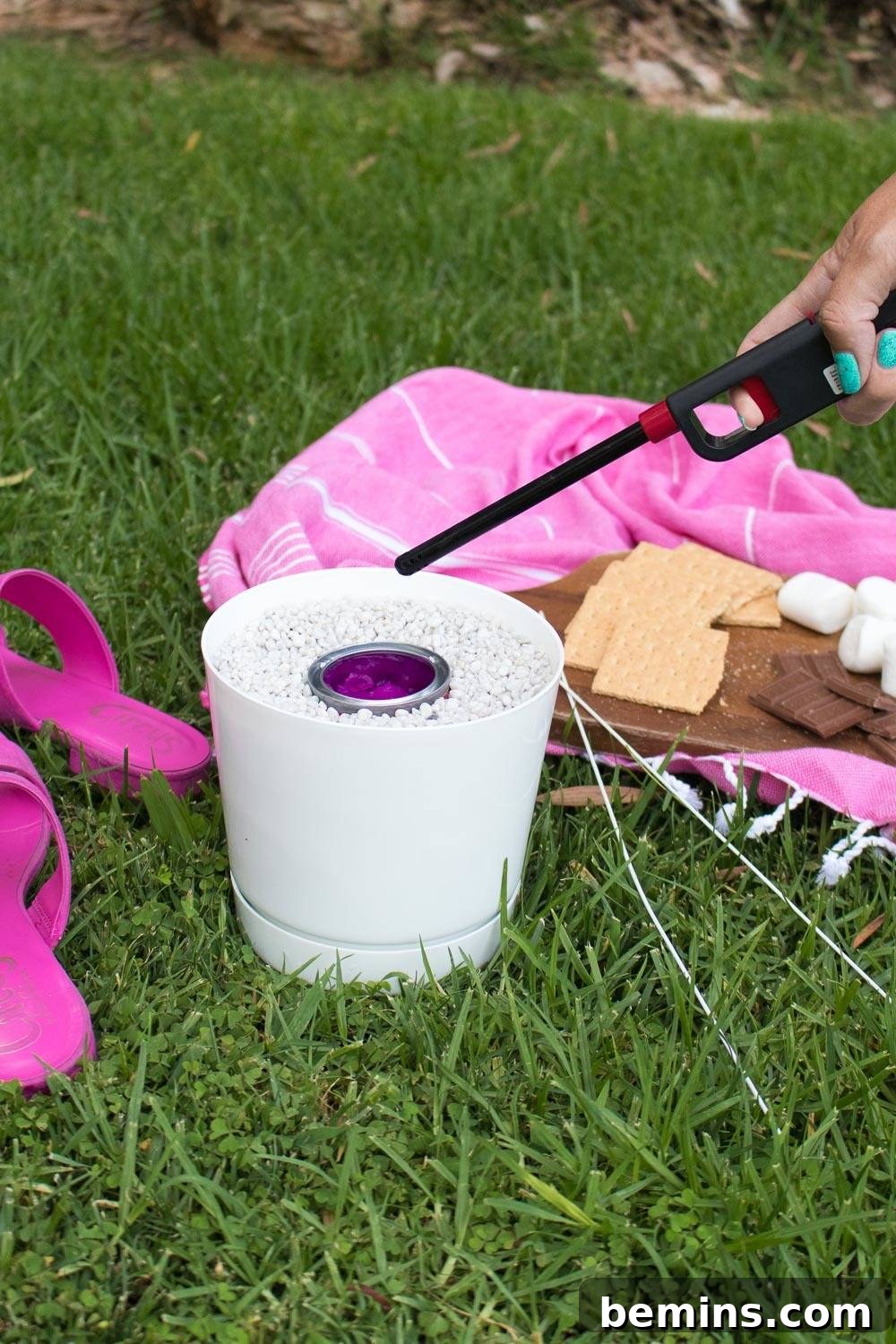 Campfire Not Required: Your Portable S'mores Fire Pot Solution 4 Detailed shot of a person using a screwdriver to carefully pry open the lid of a Sterno gel canister nestled within a rock-filled ceramic pot.