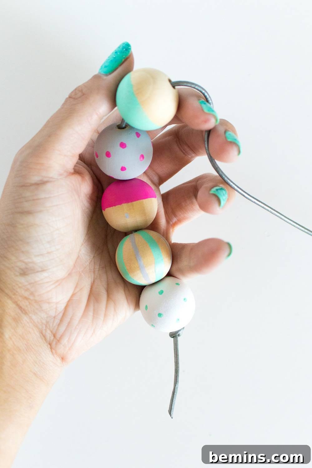 Person holding a chain of colorful painted beads