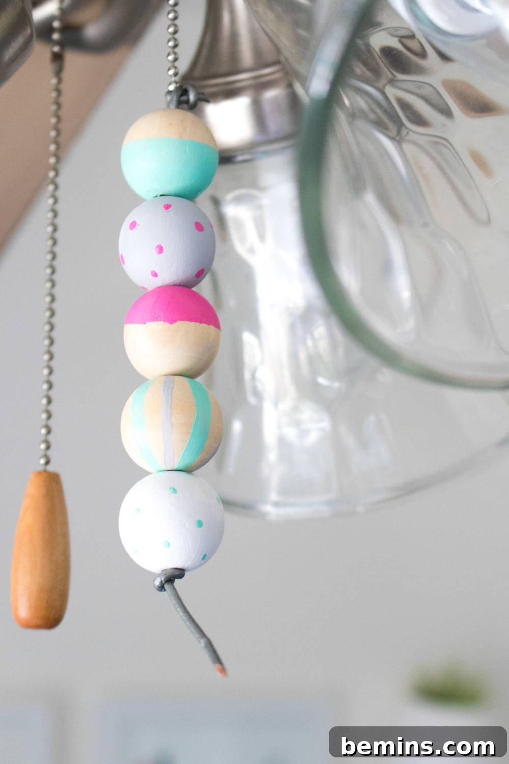 Colorful beaded fan pull hanging next to the original pull string