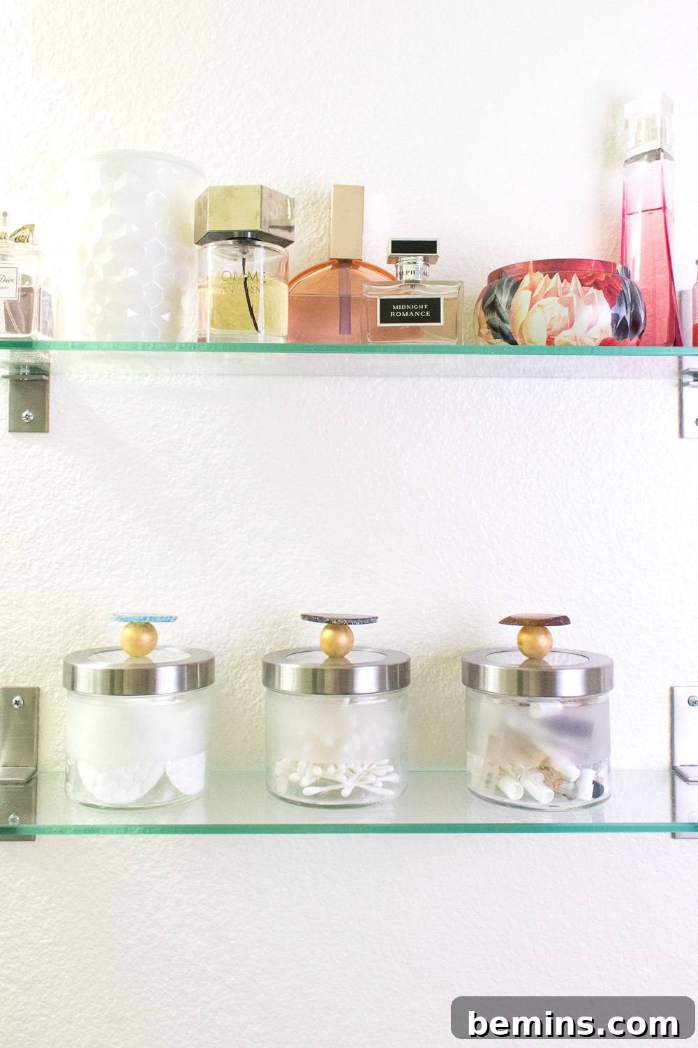 Close-up of glass shelves holding various items and perfumes, showcasing the decorated canisters.