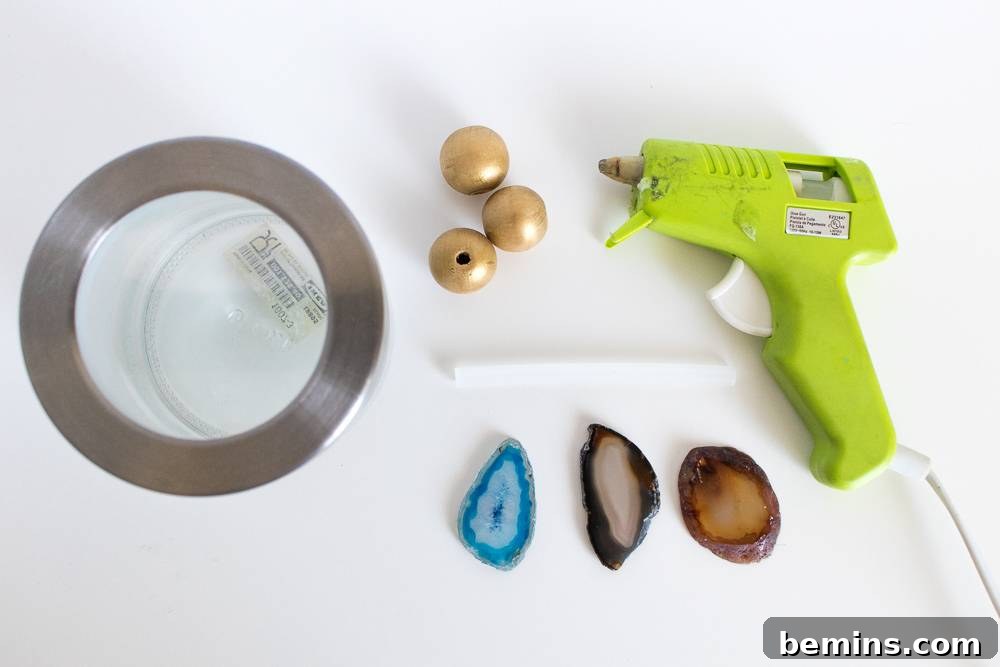 A selection of materials needed for the DIY project: glass canister, gemstones, glue gun, glue stick, and pearls.