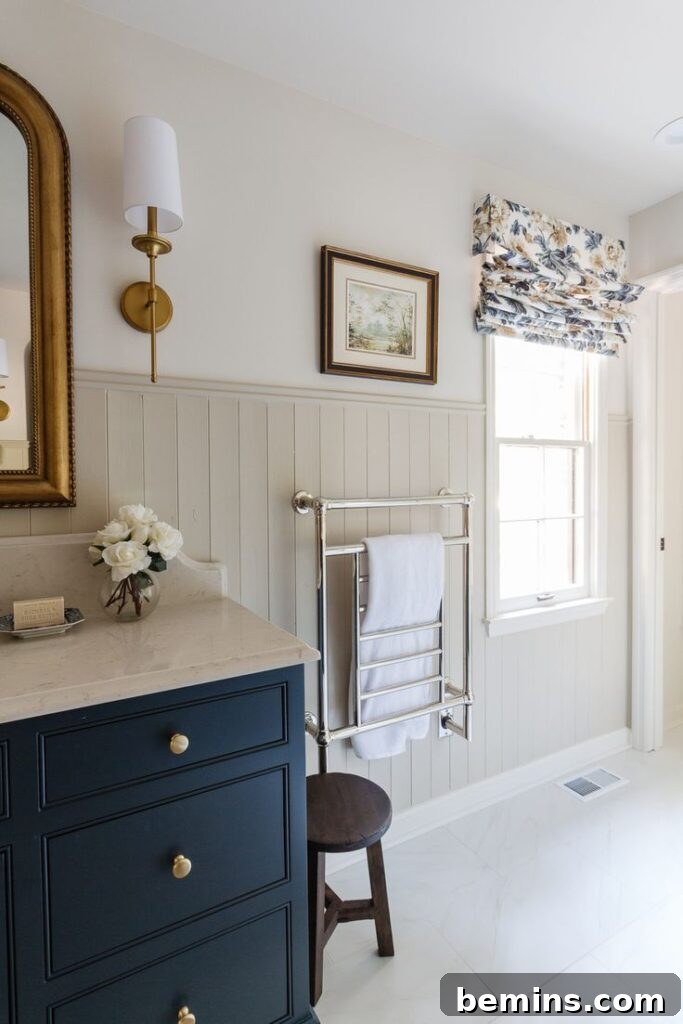 Cream bathroom wainscotting in a cream bathroom, blue sink and towel rack.