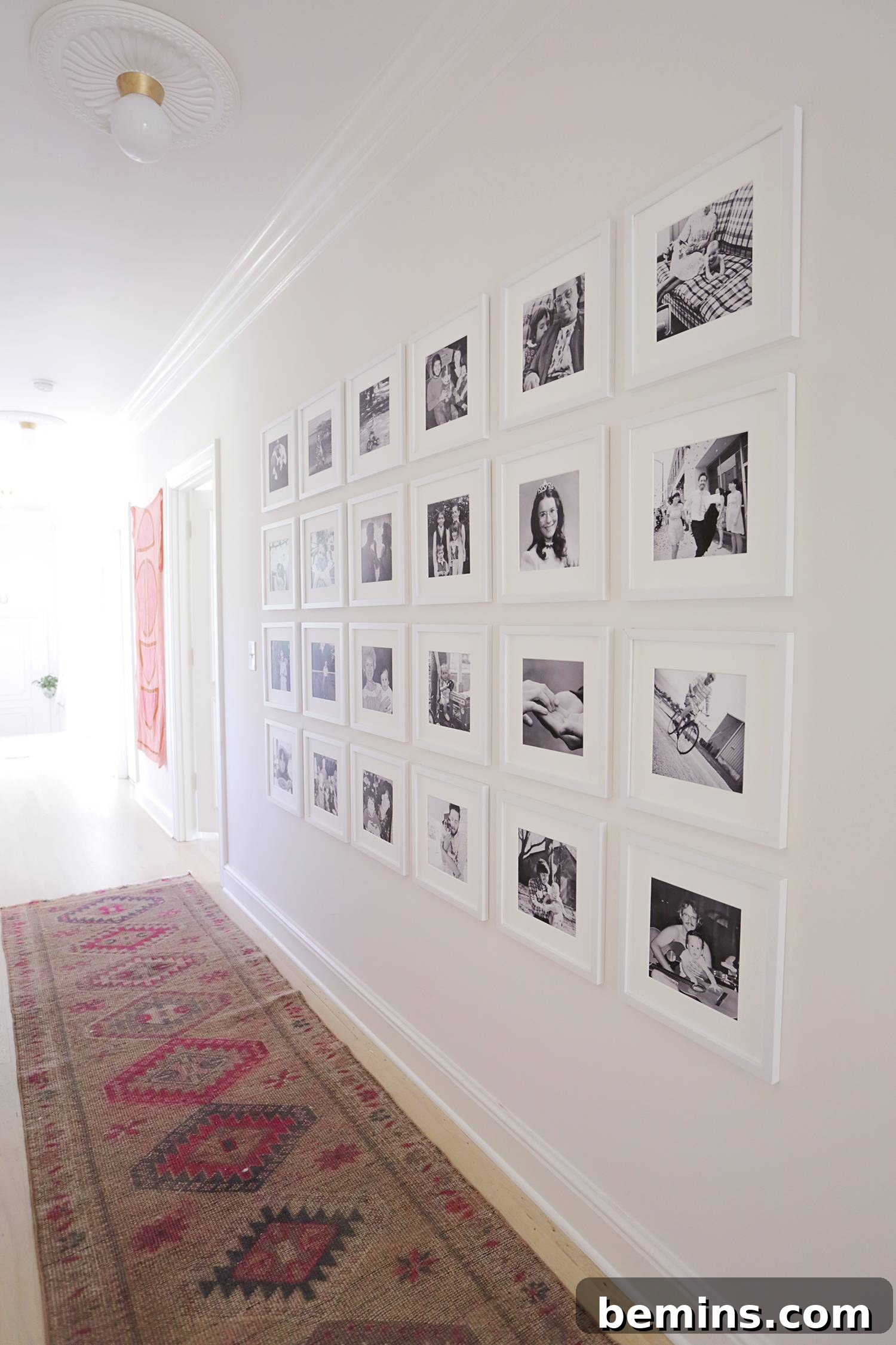 Hallway with a red and brown runner rug and black and white pictures.