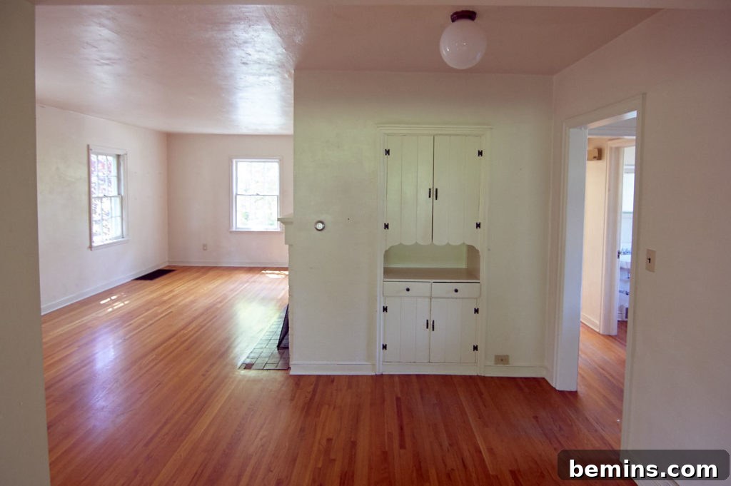 Sunlight streams into a newly renovated room, highlighting the open space created by wall removal.
