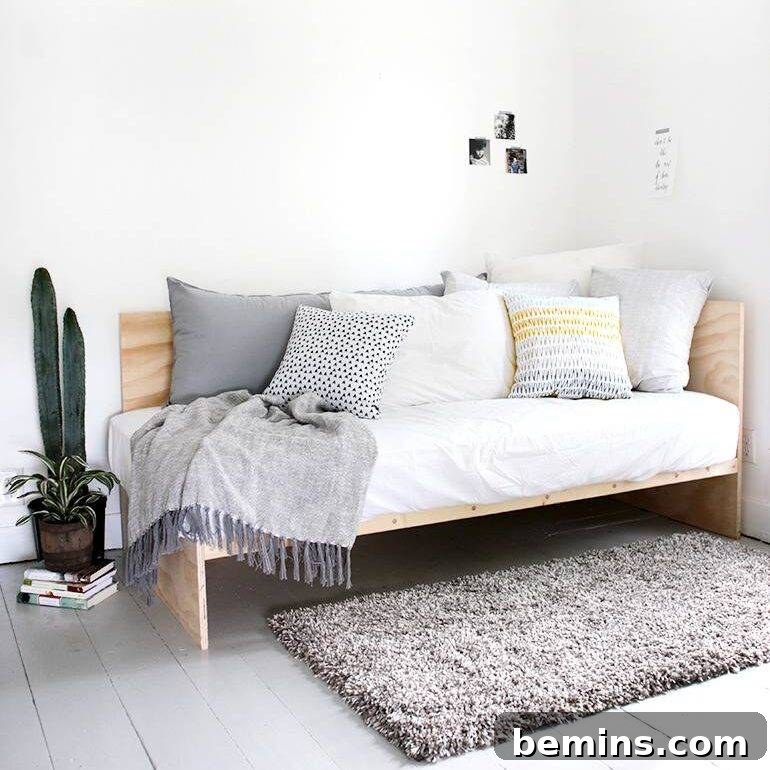 DIY Faux Fur Pouf on a Budget 17 Daybed filled with pillows in the corner of a white and grey room.