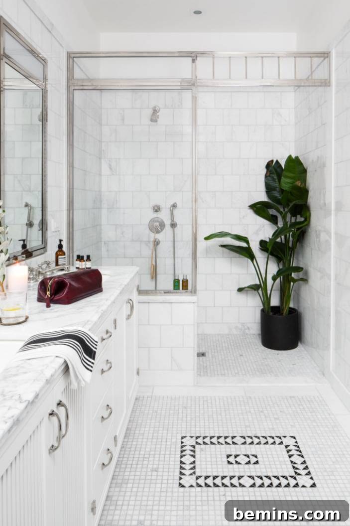 17 Stunning Bathrooms That Embrace the Shower Plant Trend 6 A white bathroom with a large green plant in the shower, a red mens shaving bag on the marble countertop and a black square tile design in the middle of the floor.