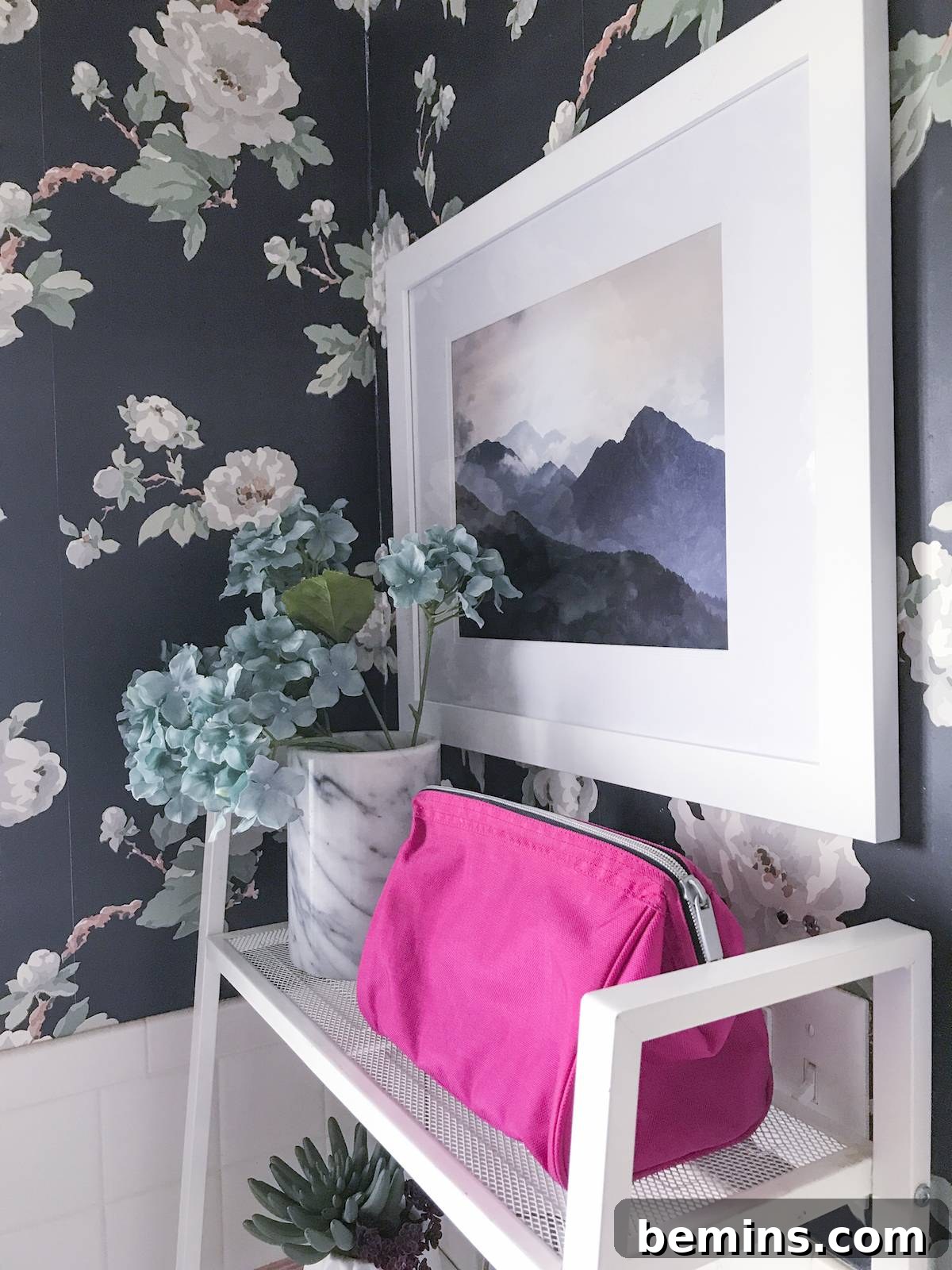 A mountain print art piece that complements the bathroom's color scheme.