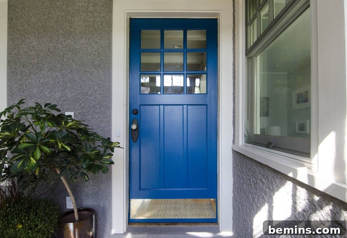 A beautifully painted blue front door with a vibrant plant beside it, enhancing the curb appeal of the home.