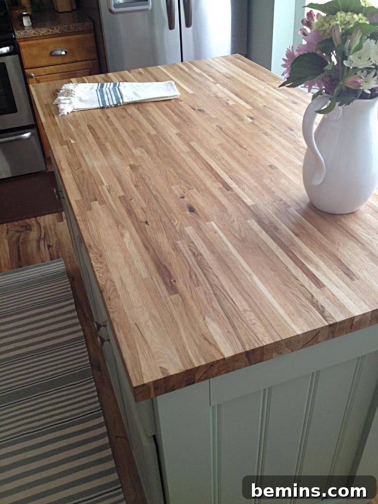 A wooden table has a white vase and a towel on it.