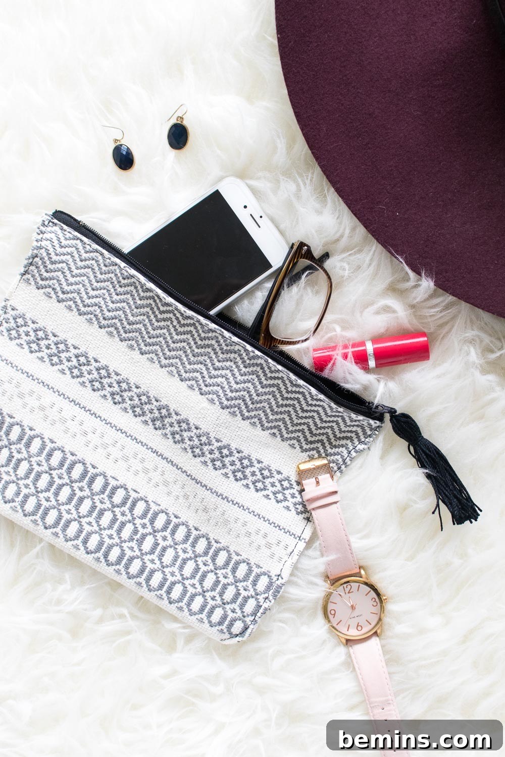 Grey and white clutch with a watch and iPhone