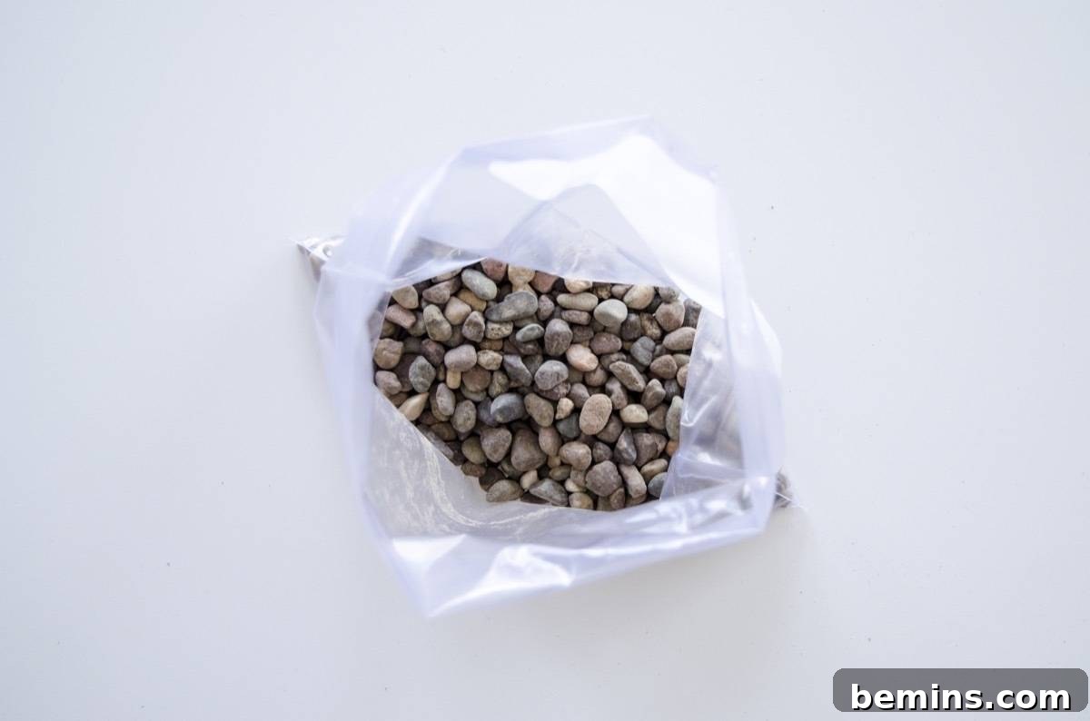 Adding river rocks to the plastic bag for proper plant drainage