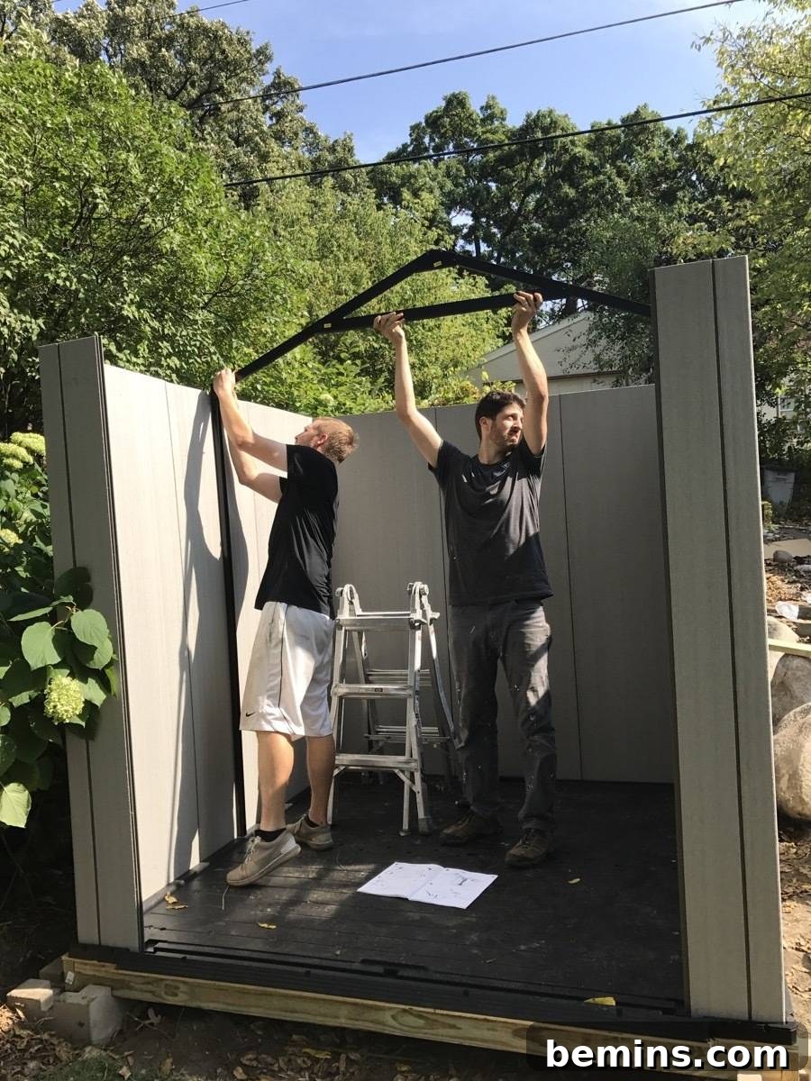 Two people constructing a small storage shed in the backyard.