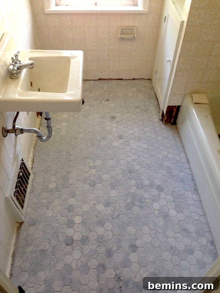 Bathroom tiles being installed around an old sink and bathtub.