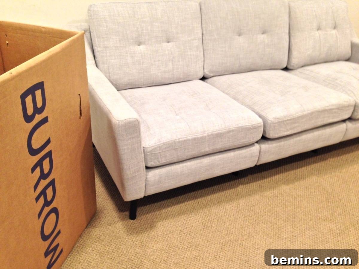 A Burrow box next to a white modern couch in the basement family room.