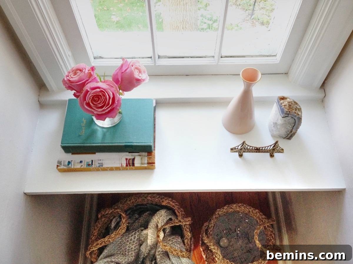 A styled desk vignette with books, roses, and decorative items in the master bedroom.