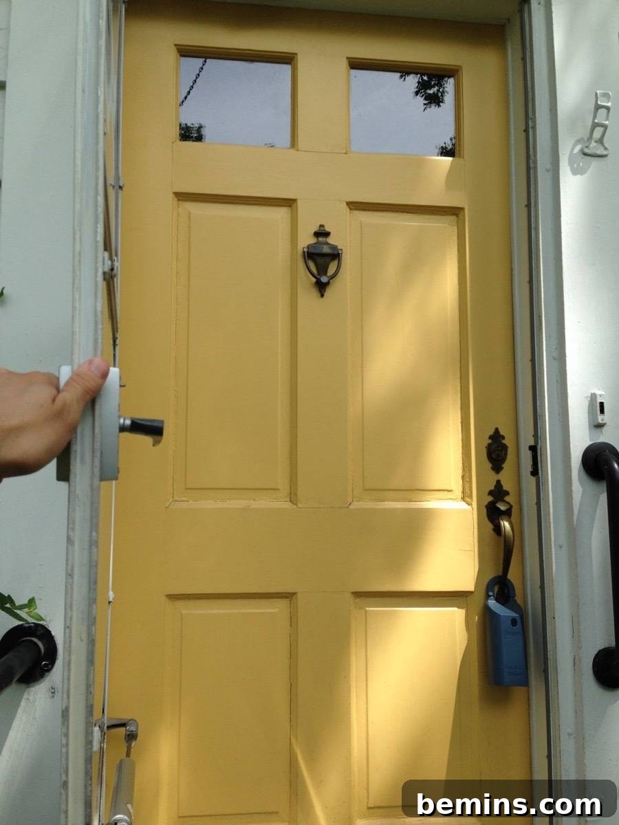 A yellow door before the renovation, contrasting with the white building.