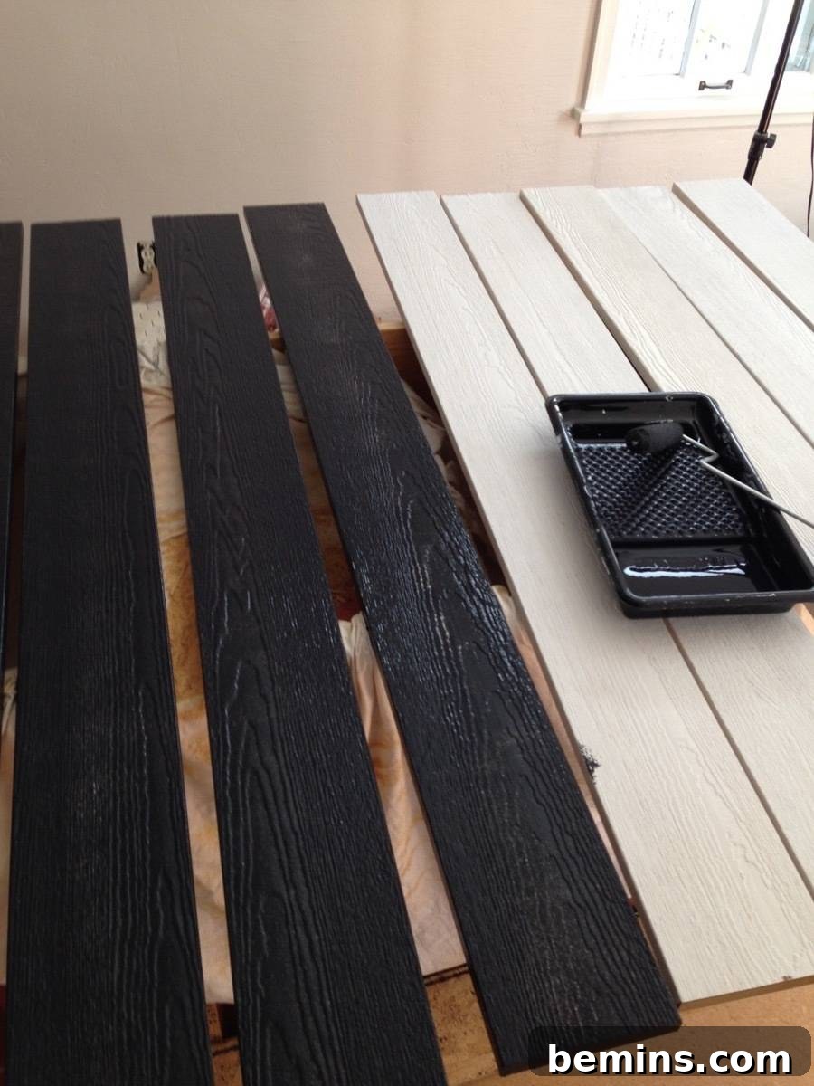 Wooden boards being painted black for custom-made shutters.