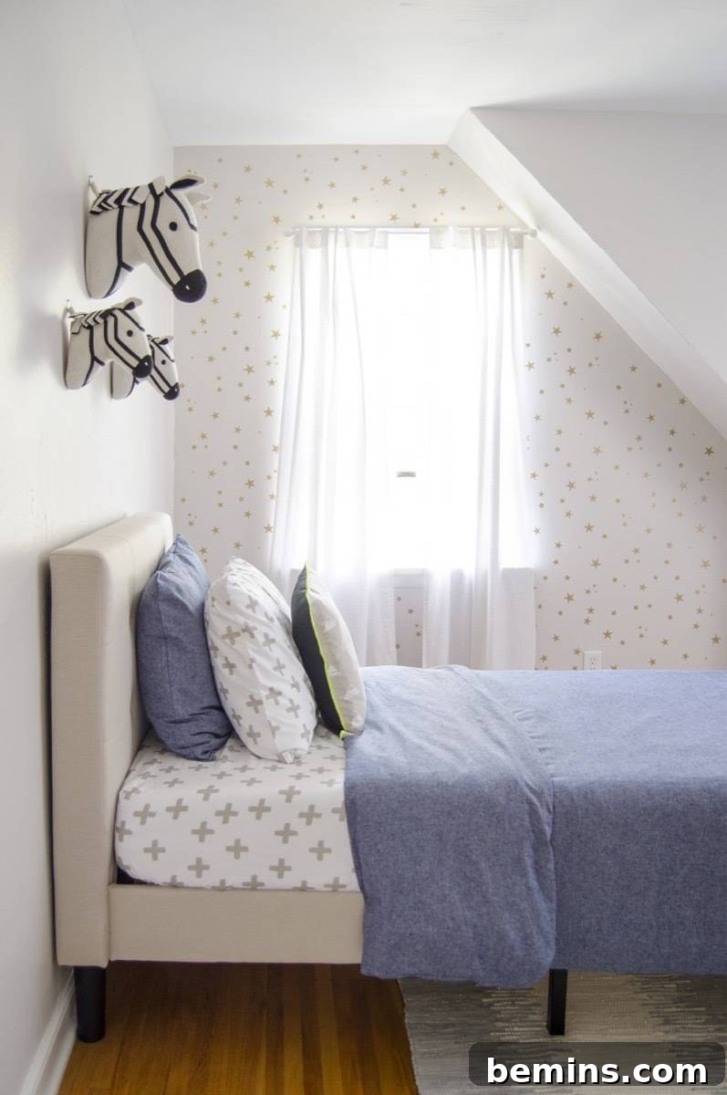 Young boy's bedroom with a small bed with a blue comforter sitting up against a white wall where horse figures are hanging. After makeover.