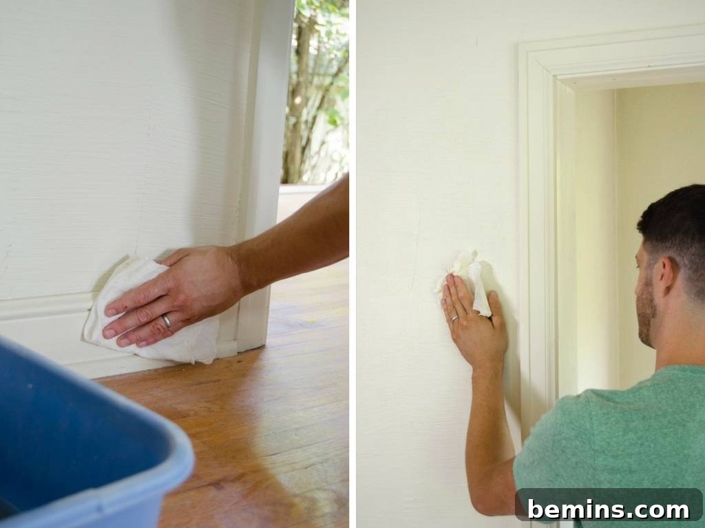 Close-up of hands washing a wall with a sponge and bucket during paint preparation.
