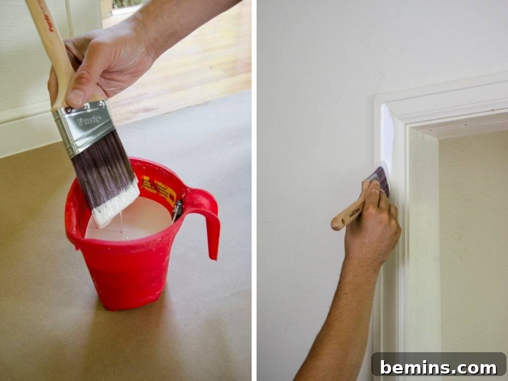 Close-up of a hand holding a Purdy paint brush and painting a wall.