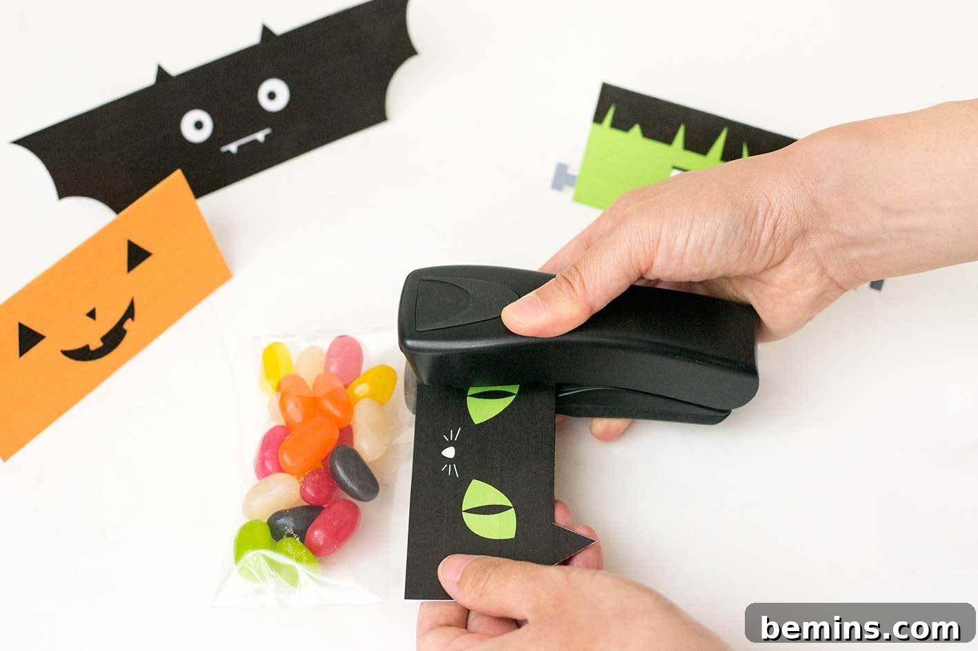 Attaching the Halloween treat bag toppers to the filled cellophane bags with a stapler