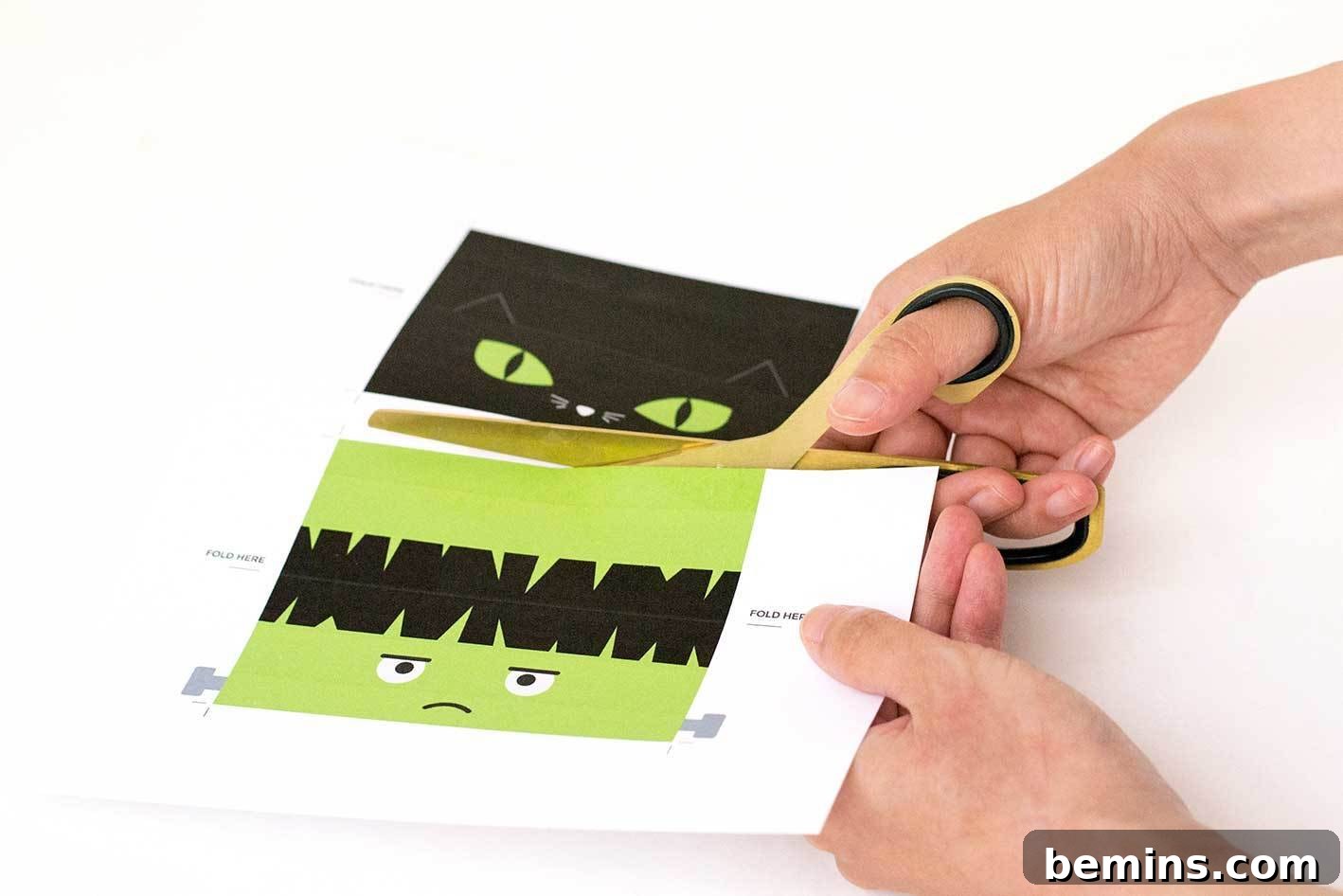 Cutting out the Halloween treat bag toppers with scissors