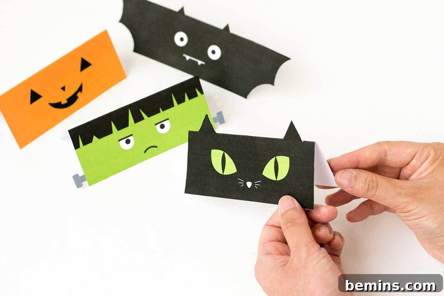 Folding the Halloween treat bag toppers along the scored line