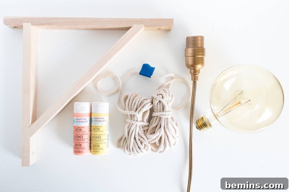 Materials needed for the DIY macrame wrapped wall light project, including macrame cord, light cord, Edison bulb, scissors, wooden shelf bracket, and optional paint and paintbrushes.