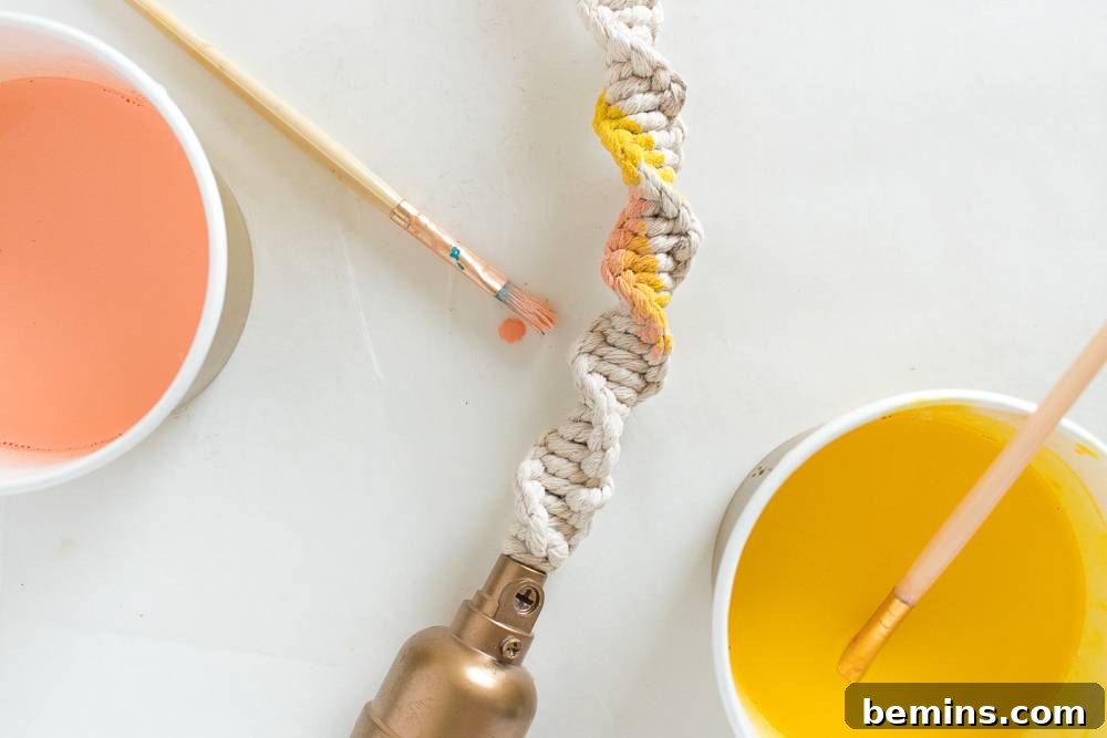 A close-up shot of the braided macrame string after being dyed with pink and yellow paint, showcasing the watercolor effect.