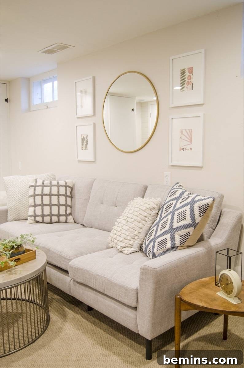 Cream-colored living space with art on the wall above sofa and tables.