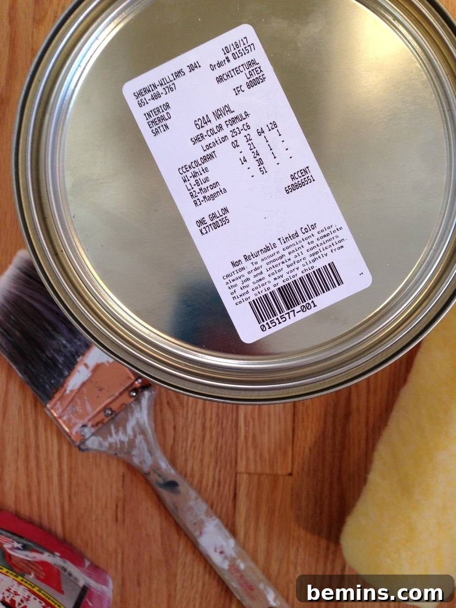 A price tag sticker is attached to the top on a paint can next to a brush.