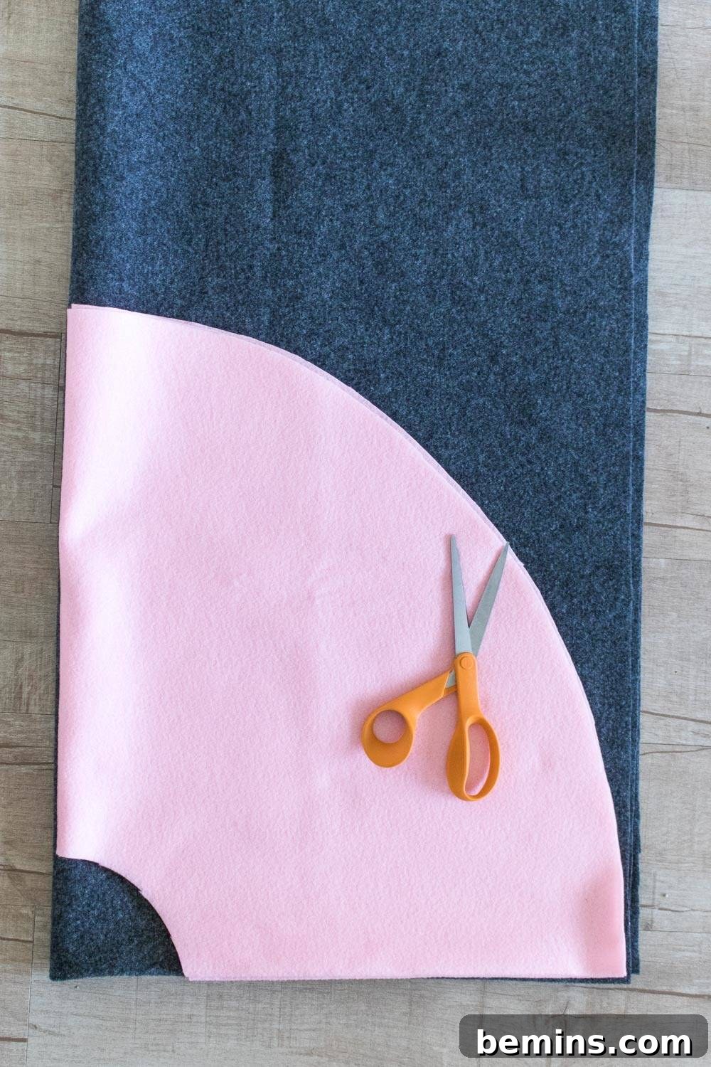 Orange-handled scissors on blue and white patterned fabric, showcasing crafting in progress