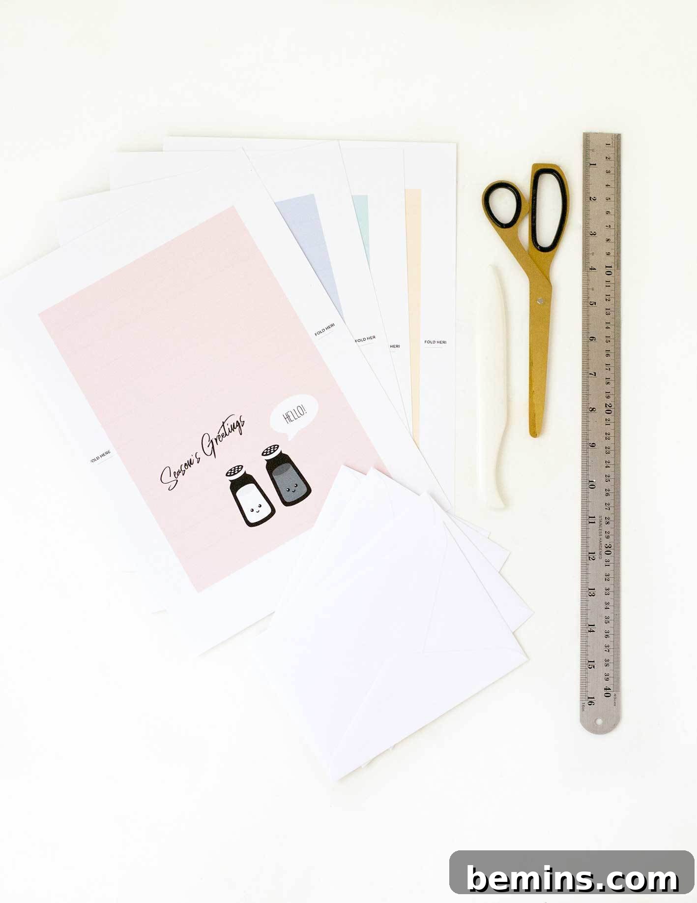 All the materials needed to make the punny Christmas cards laid out on a table.